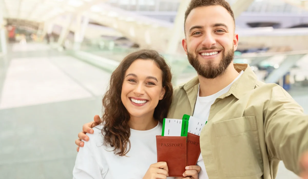 joyful-couple-taking-selfie-with-passports