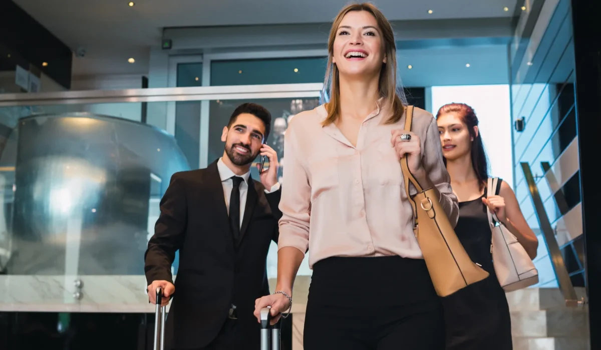 portrait-business-people-arriving-hotel-walking-through-lobby-with-their-luggage-travel-business-concept